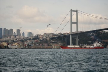 Obraz premium First Bosphorus bridge with ship in transit, Istanbul, Turkey