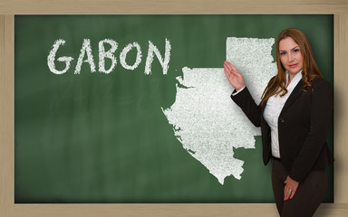 Teacher showing map of gabon on blackboard