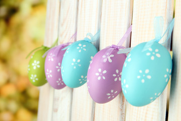 Art Easter background with eggs hanging on fence