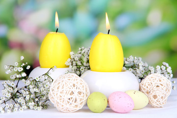 Obraz na płótnie Canvas Easter candles with flowers on bright background