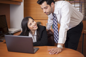 Beautiful businesswoman flirting with her colleague at work