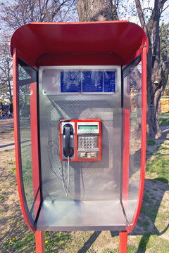Orange public telephone on metallic background