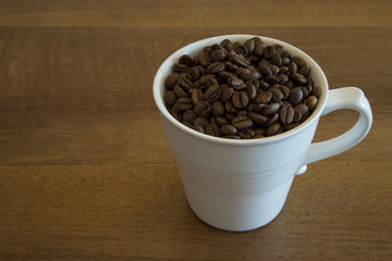Coffee cup filled with coffee beans