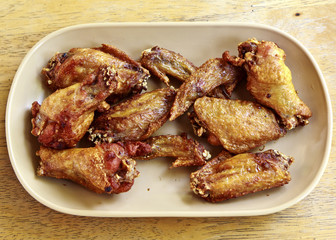 chicken wings in white dish on wooden background