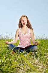 Portrait girl sits on a grass