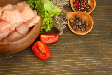 raw chicken meat in bowl, on wooden background