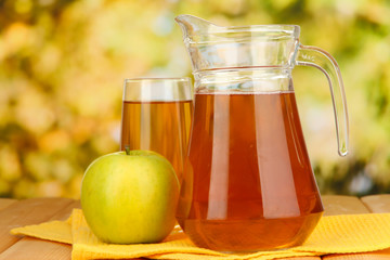 Full glass and jug of apple juice and apple