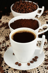 Different types of coffee in three cups on wooden table