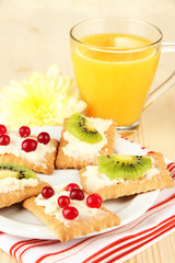 Tasty canapes with cheese and kiwi, cranberry,