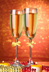 Two glasses of champagne on bright background with lights