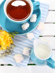 Beautiful tea composition on wooden picnic table close-up
