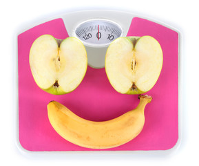 Apple and banana on scales isolated on white