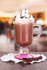 Layered coffee in glass on table on bright background