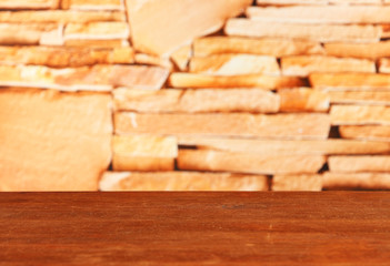 Wooden table on bricks background