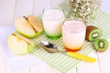 Obraz na płótnie Canvas Delicious yogurts with fruits in glasses