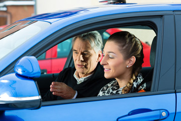 Junge Frau in einem Fahrschulauto