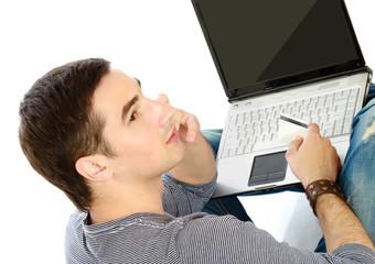 A young man sitting on the floor with a laptop and credit card