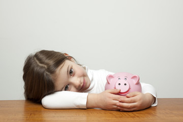 Little girl with piggy bank