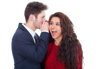 Man whispering a secret to a surprised young lady