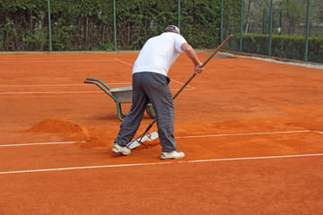 Obraz premium Worker fixes the lines on tennis courts