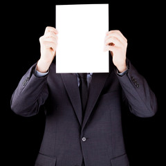 Businessman holding  a sheet of paper in front of his face