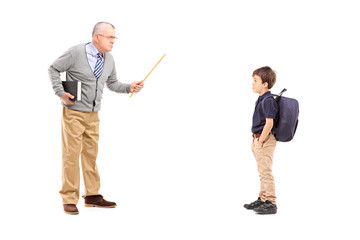 Full length portrait of an angry teacher shouting at a schoolboy