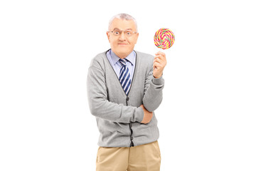 Mature man holding a colorful lollipop
