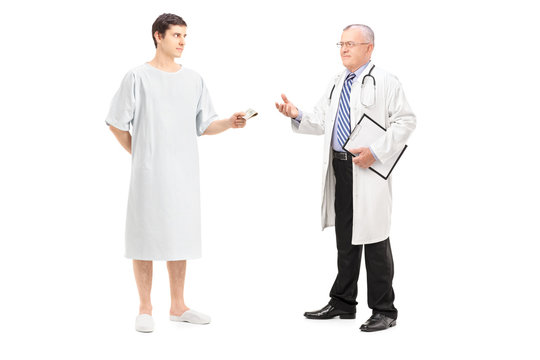 Full length portrait of a male patient offering money to a docto
