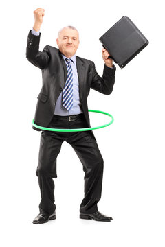 Full length portrait of a matue businessman dancing with a hula