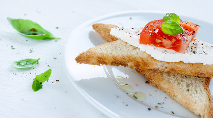 Toast with cottage cheese, tomato slice and fresh basil