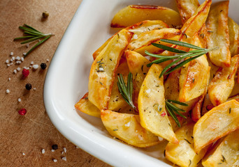 Roasted potatoes with rosemary in a white bowl