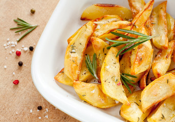 Roasted potatoes with rosemary in a white bowl