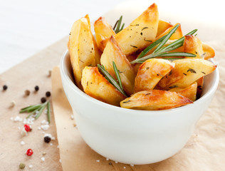 Roasted potatoes with rosemary in a white bowl