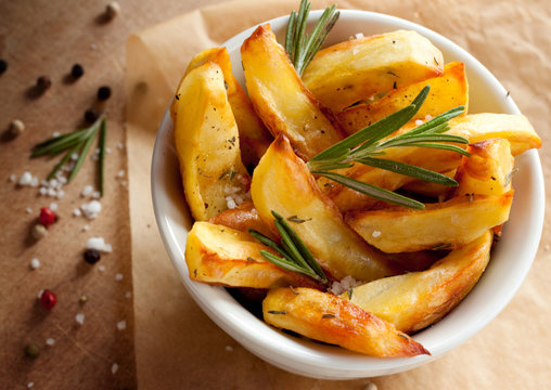 Roasted potatoes with rosemary in a white bowl