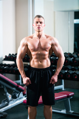 Fototapeta na wymiar Bodybuilder posing in Gym