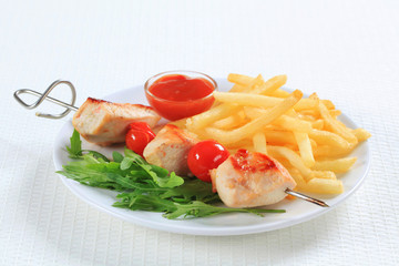 Chicken skewer with fries and ketchup
