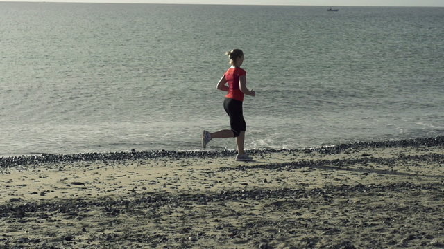 Woman jogging on the beach, super slow motion, shot at 240fps