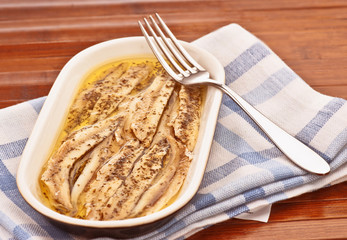 tray of anchovies with pickled garlic and parsley oil