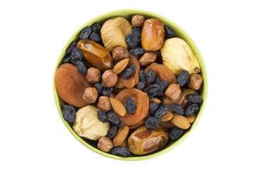 Dried fruits and nuts mixed in green bowl isolated on white