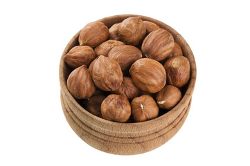 Shelled raw hazelnuts in wooden bowl isolated on white