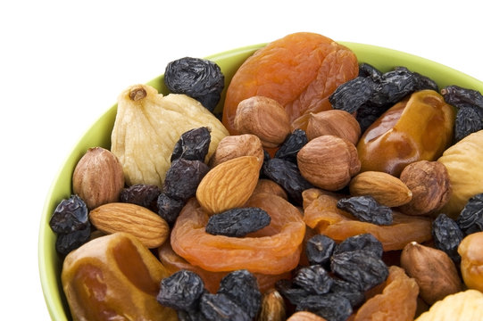 Dried fruits and nuts mixed in green bowl close up - Powered by Adobe