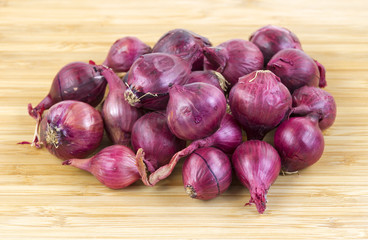 Red pearl onions on cutting board