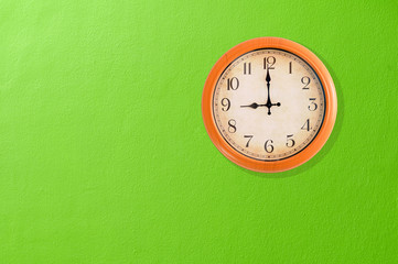 Fototapeta na wymiar Zegar pokazujący godzina dziewiąta na zielone ściany