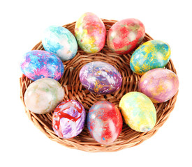 Beautiful Easter eggs in wicker basket isolated on white