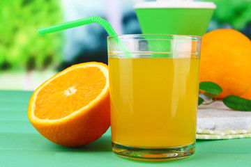 Glass of juice, citrus press and ripe orange