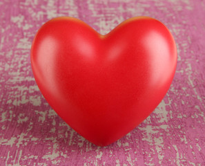 Decorative red heart on color wooden background