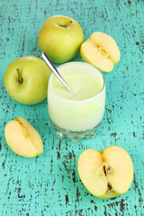 Delicious yogurt in glass with apple on wooden table close-up