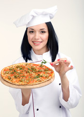 Beautiful girl chief-cooker with pizza isolated on white