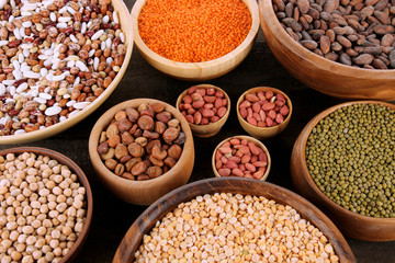 Different kinds of beans in bowls on  table close-up