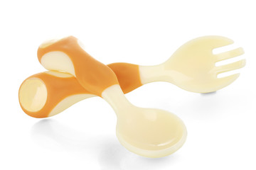 Small beige spoon and fork for babies isolated on white